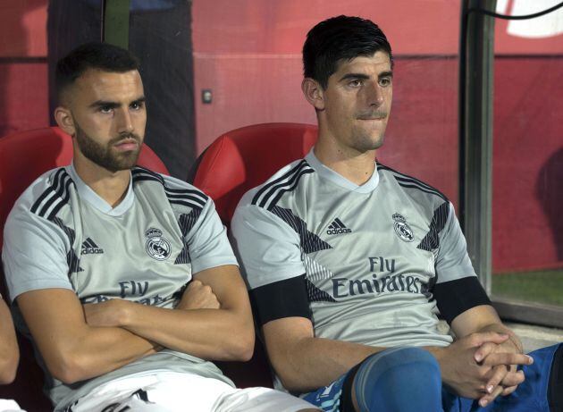 Los jugadores del Real Madrid, el guardameta belga del Real Madrid, Thibaut Courtois (d) y Borja Mayoral, siguen desde el banquillo blanco el encuentro correspondiente a la segunda jornada de primera división que disputan esta noche frente al Girona en el estadio Municipal de Montilivi, en la capital gerundense.