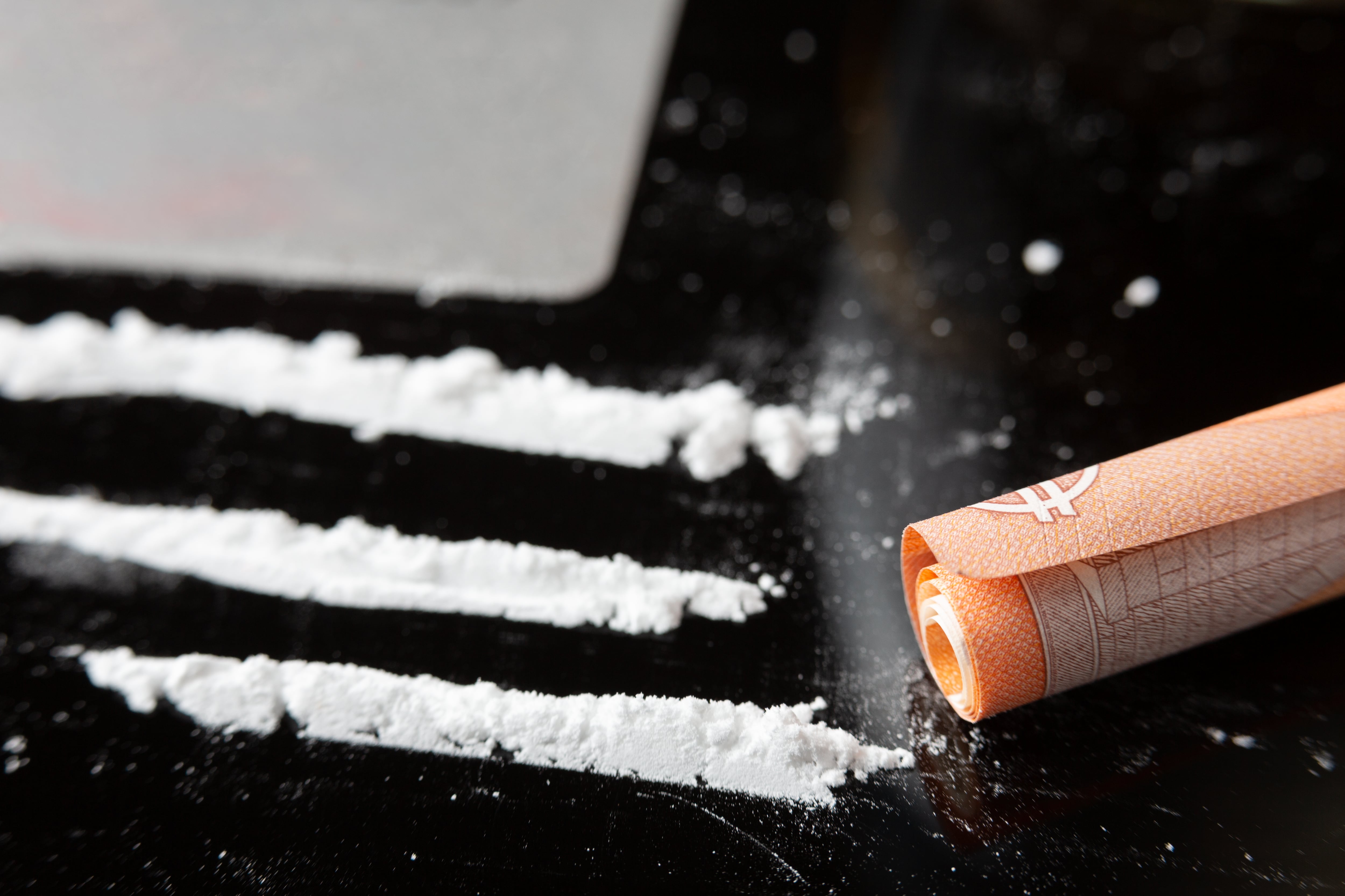 Cocaine lines prepared on a table and a rolled banknote ready to be sniffed