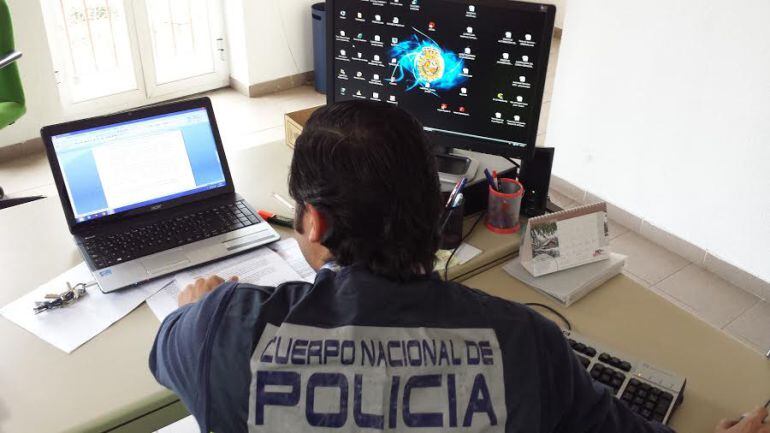 Agentes durante la inspección de varios ordenadores personales