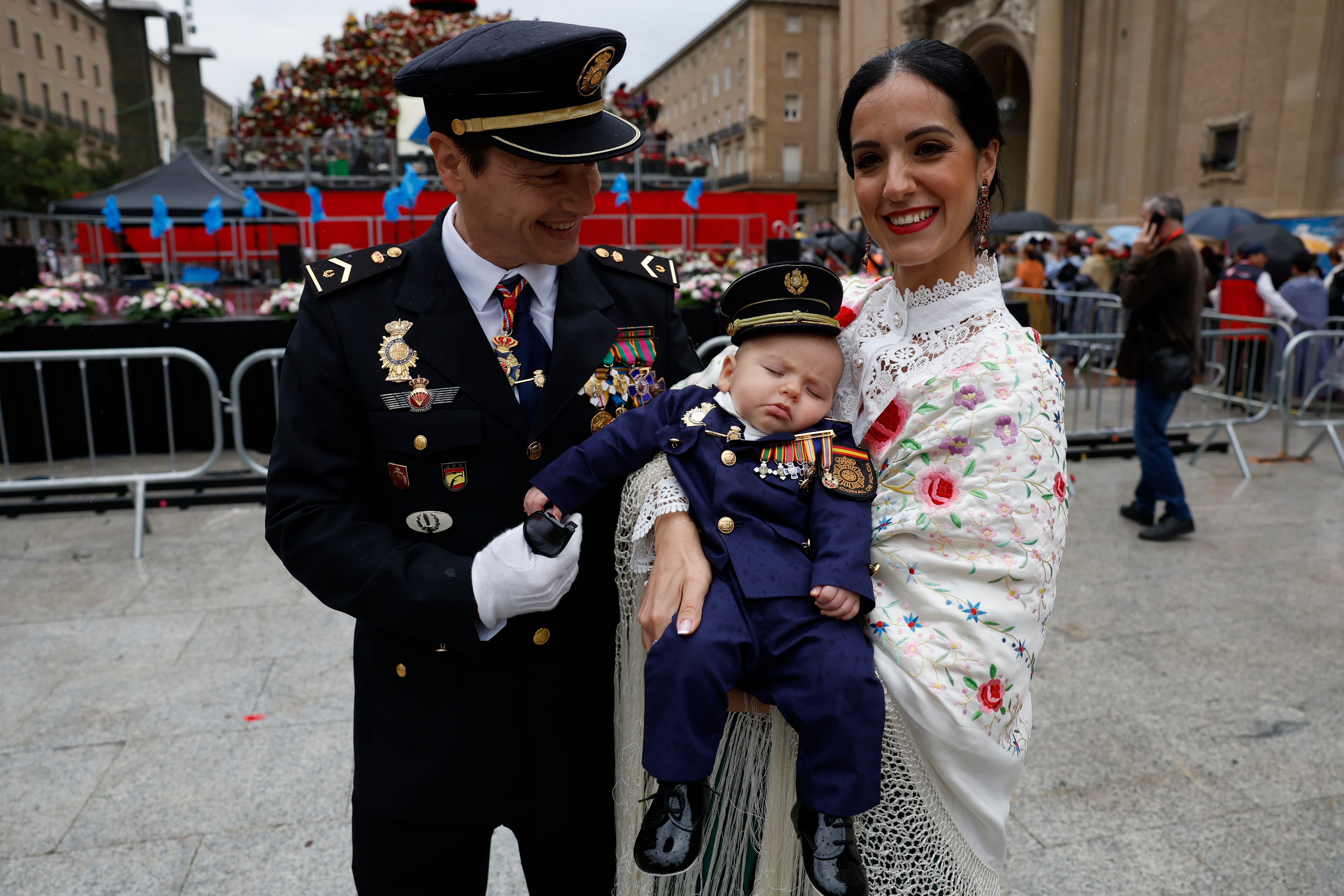 ZARAGOZA, 12/10/2024.- Una pareja y su hijo posan ante la Virgen del Pilar durante la tradicional Ofrenda de Flores a la Virgen este sábado en Zaragoza. EFE/ Javier Cebollada
