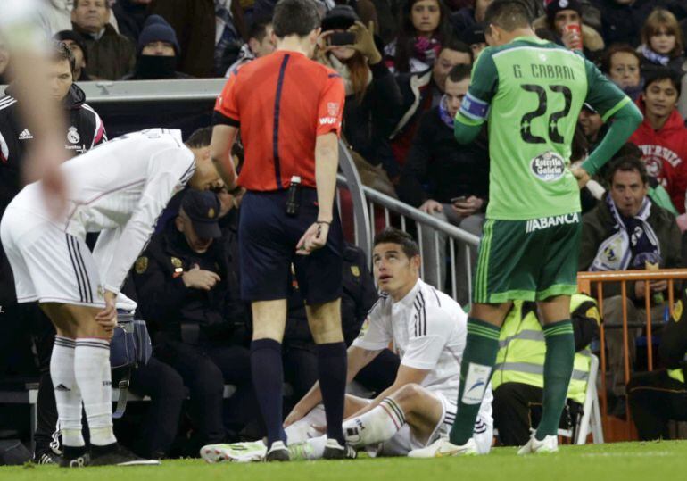 El centrocampista colombiano del Real Madrid James Rodríguez en el suelo tras lesionarse durante el partido correspondiente a la decimocuarta jornada de Liga que disputan frente al Celta en el estadio Santiago Bernabéu de Madrid