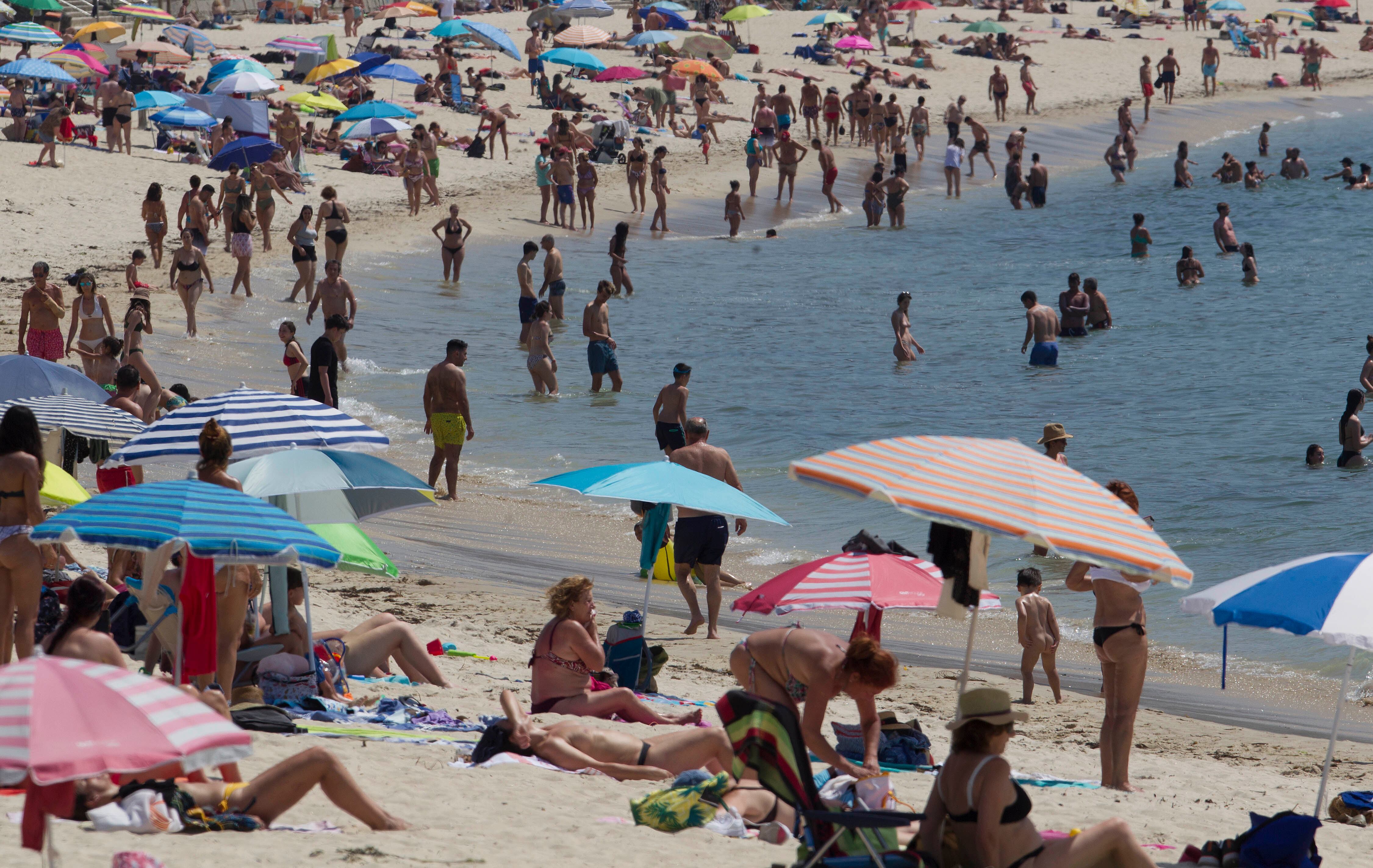 GRAF902. VIGO, 13/06/2022.-Cientos de personas se han acercado este lunes a la playa de Samil de Vigo para intentar mitigar las altas temperaturas registradas en la región. EFE / Salvador Sas
