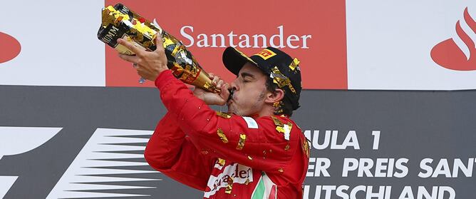 El piloto español bebe la tradicional botella de cava tras ganar el GP de Alemania, su tercera victoria del año