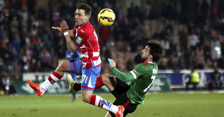 GRA366. GRANADA. 14/02/2015.- El delantero del Granada CF, Adrián Colunga (i), lucha el balón con Beñat Etxebarria, del Athletic Club, durante el partido correspondiente a la vigésimo tercera jornada de Liga en Primera División que se juega esta tarde en el estadio de Los Cármenes, en Granada. EFE/Miguel Ángel Molina