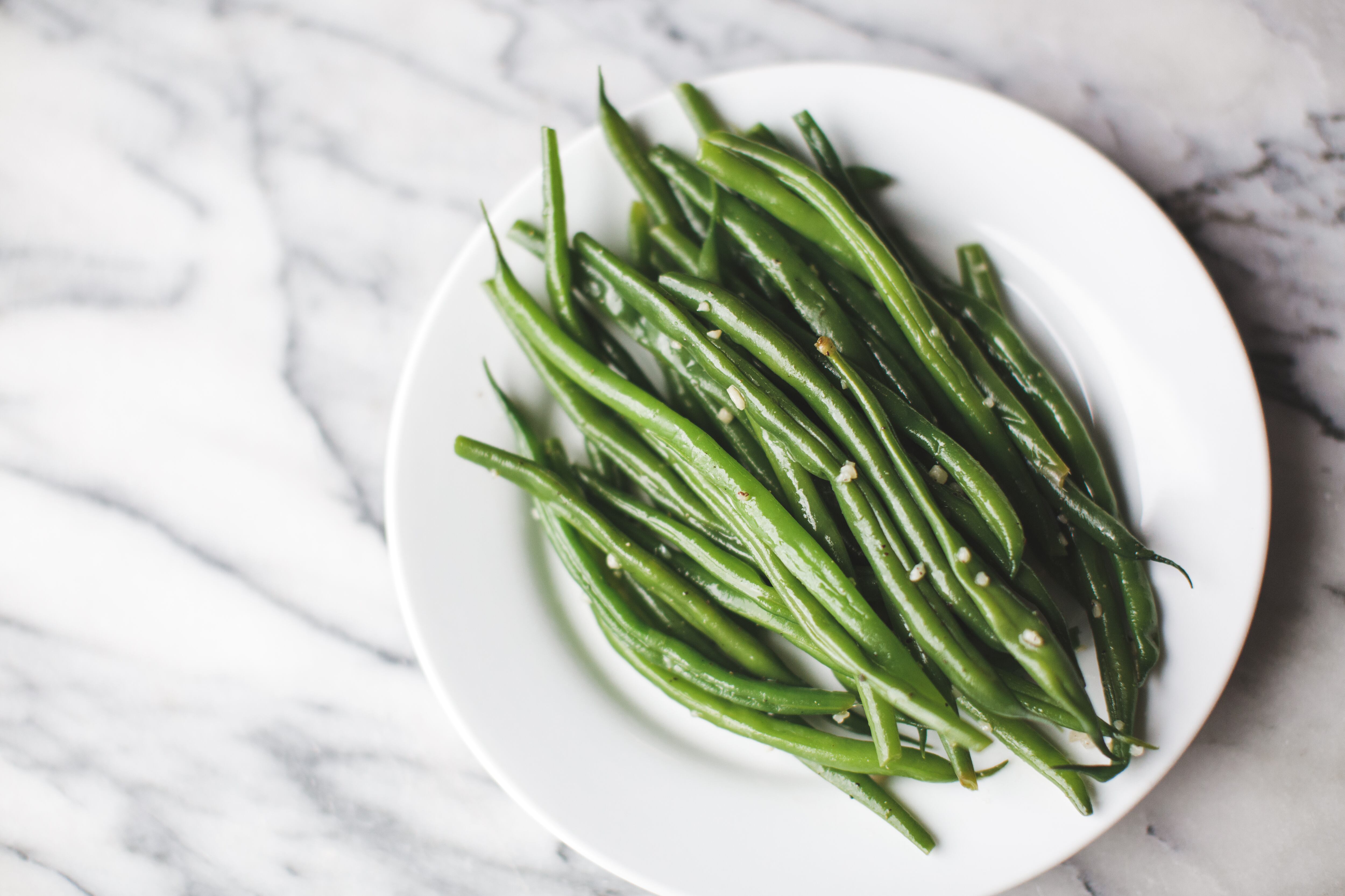 Green beans cooked and seasoned on a plate.