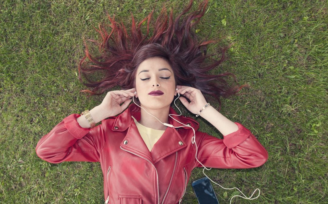 Una mujer escuchando música con su teléfono móvil.