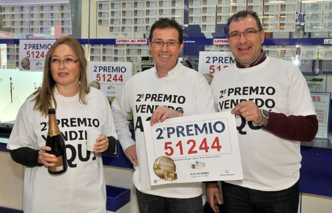 Responsables de la administración nº 20 de Albacete muestran el cartel del segundo premio del Sorteo Extraordinario de la Lotería de Navidad, el 51.244, vendido en el local, que ha repartido 1.375.000 euros en Albacete capital, y en Daimiel, a través de u