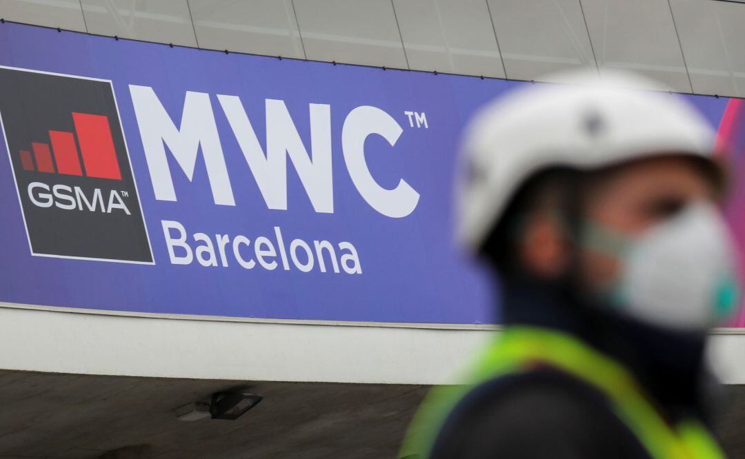 An employee is pictured next to the logo of MWC20 (Mobile World Congress) in Barcelona, Spain February 12, 2020