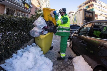 Operarios del servicio de limpieza retiran los cubos de basura de las calles de Madrid tras reiniciarse ayer el servicio de recogida suspendido tras el paso de la borrasca Filomena.