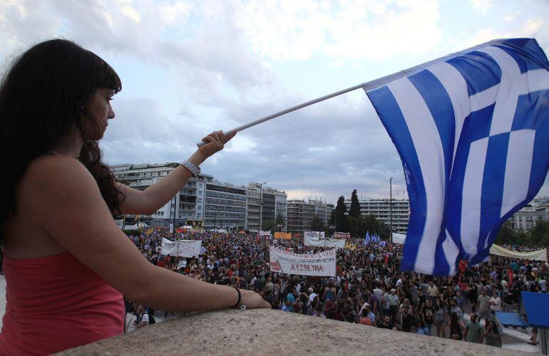 Una joven con la bandera nacional de Grecia en la plaza de Syntagma.