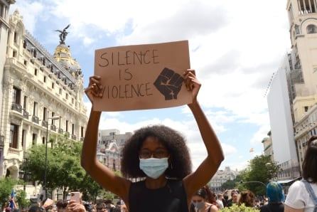 Una chica levanta su pancarta, en la que puede leerse &quot;Silence is violence&quot; (&quot;El silencio es violencia&quot;).