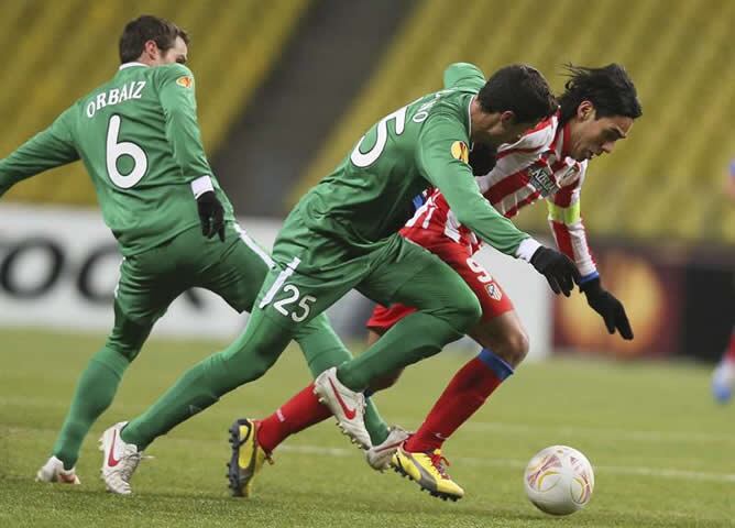 El delantero colombiano del Atlético Madrid, Radamel Falcao (d), lucha por el balón con los españoles Iván Marcano (c), y Pablo Orbaiz (i), del Rubin Kazán, durante el partido de vuelta de dieciseisavos de la Liga Europa de fútbol que ambos equipos han di