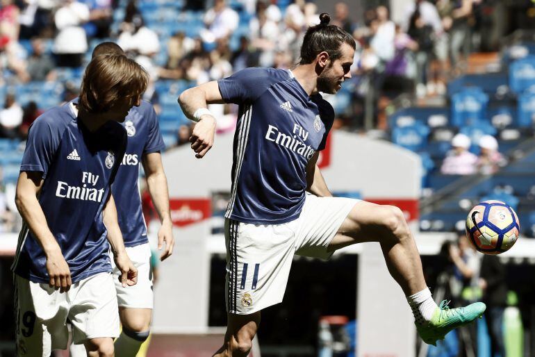 Los jugadores del Real Madrid el galés Gareth Bale (d) y el croata Luka Modric (i) durante el calentamiento previo al partido, ante el Atlético de Madrid, correspondiente a la trigésimo primera jornada de LaLiga Santander que se disputa hoy en el estadio 