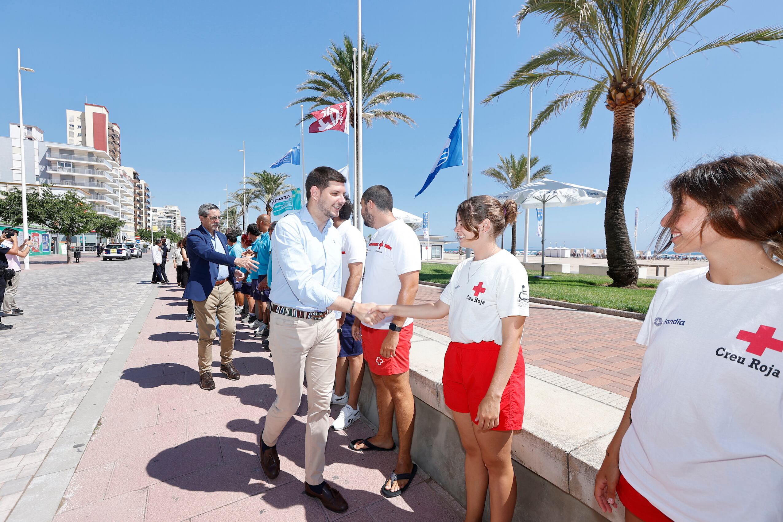 El alcalde de Gandia en el acto de hizada de banderas, saludando al equipo de Cruz Roja.
