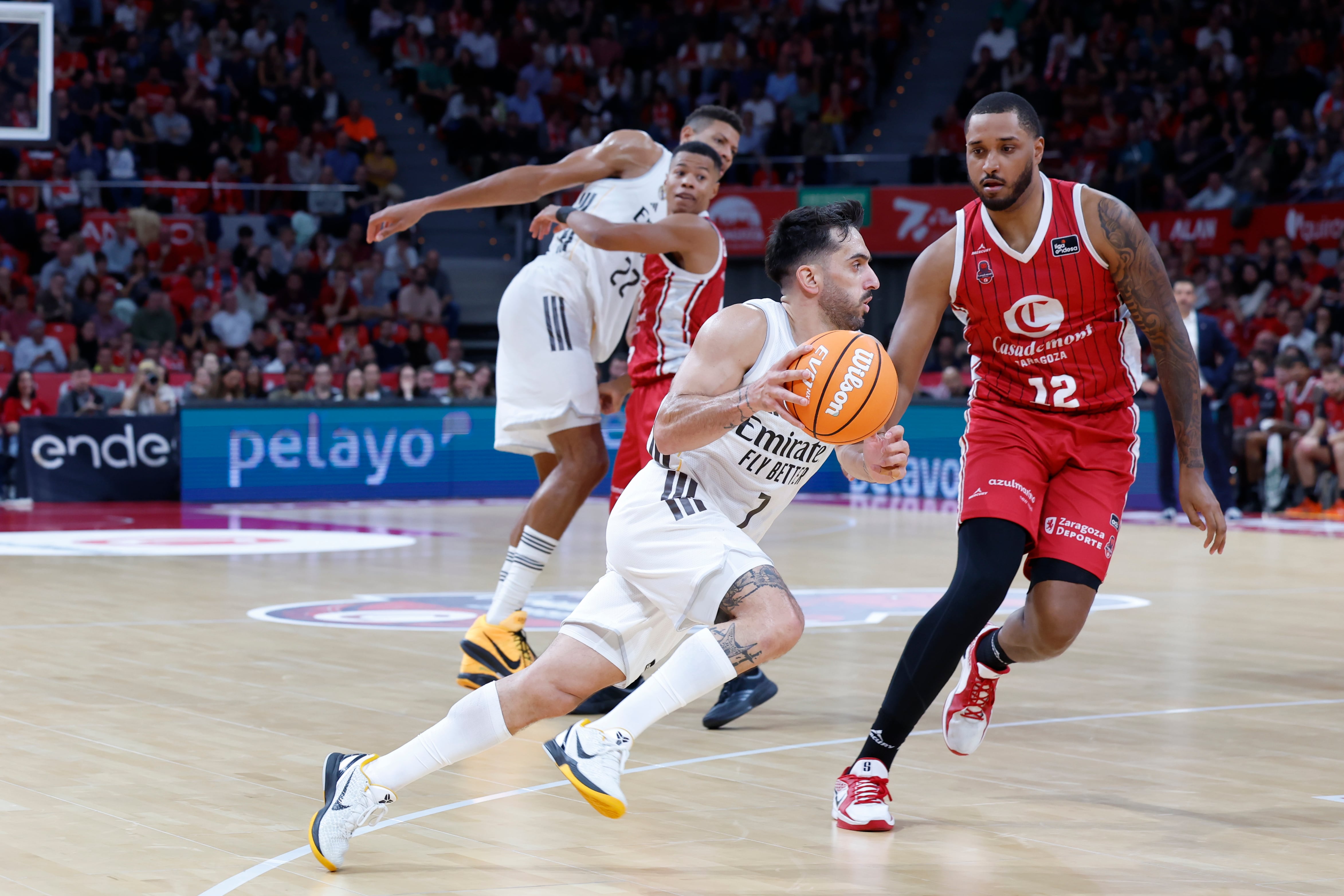 ZARAGOZA, 02/11/2025.- El base del Real Madrid Facundo Campazzo (c) intenta superar la defensa del pívot Joel Soriano (d), del Casademont Zaragoza, durante su partido de la Liga ACB de baloncesto disputado este domingo en el Pabellón Príncipe Felipe de Zaragoza. EFE/ Javier Cebollada