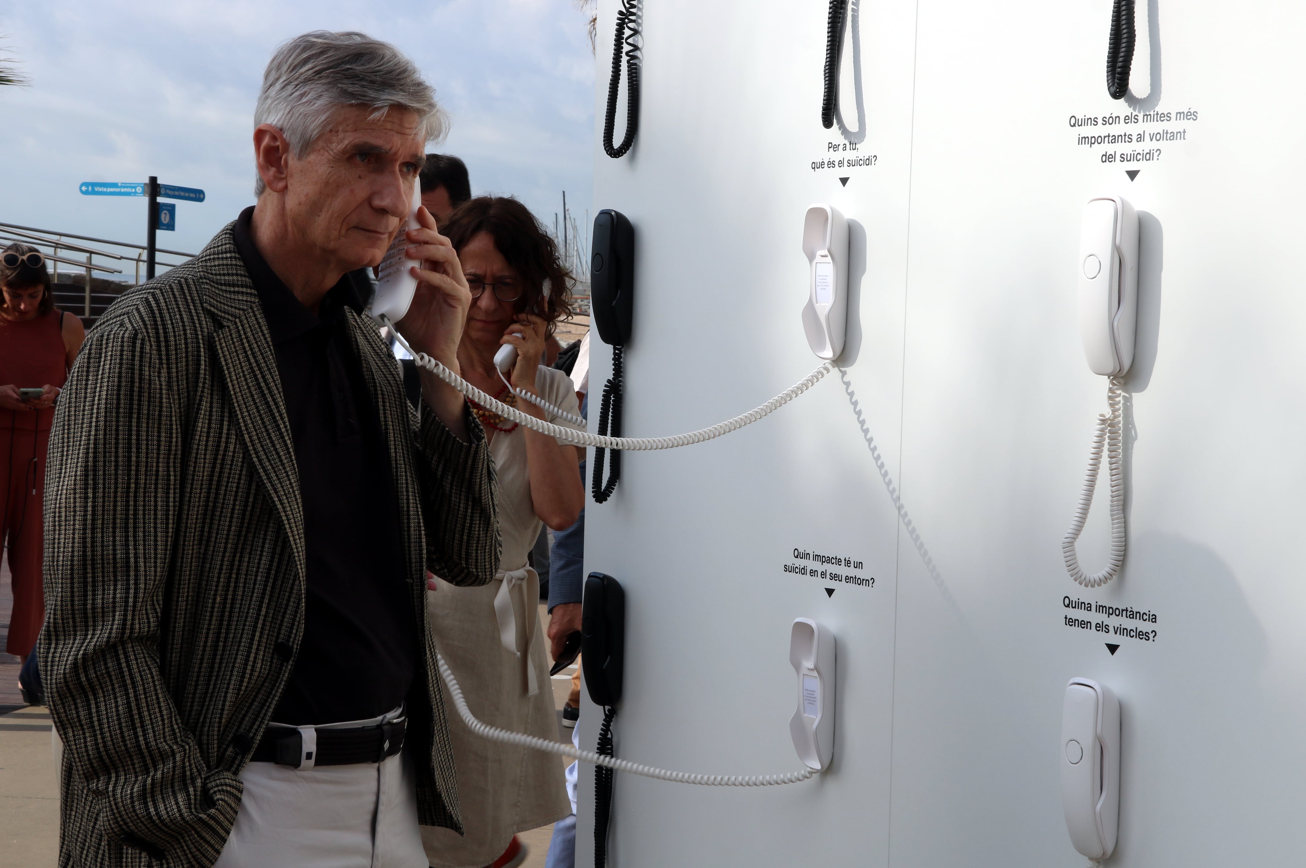 Argimon escoltant els àudios de l'experiència immersiva per promocionar el telèfon d'atenció al suïcidi al passeig Marítim de Badalona