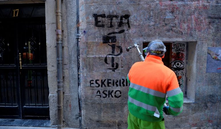 Un operario borra una pintada de agradecimiento a ETA en Bilbao.