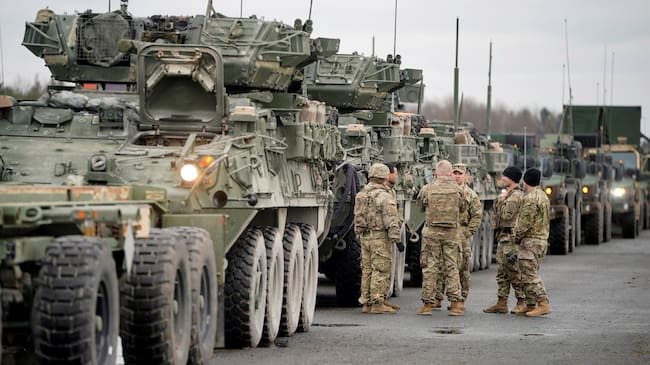 Soldados del 2º Regimiento de Caballería de Estados Unidos conversa junto a varios vehículos militares antes de partir a Rumanía, en la Base Aérea estadounidense de Vilseck (Alemania) este miércoles.
