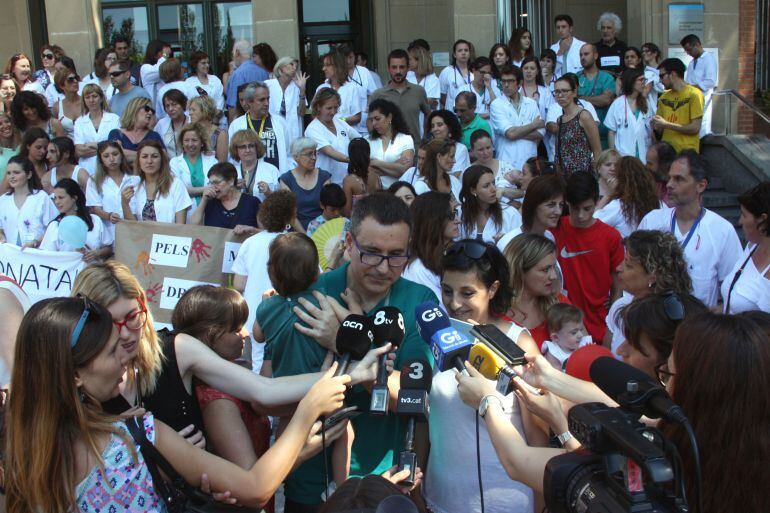 El conseller Toni Comín envoltat de sanitaris protestant pel mal estat del Trueta