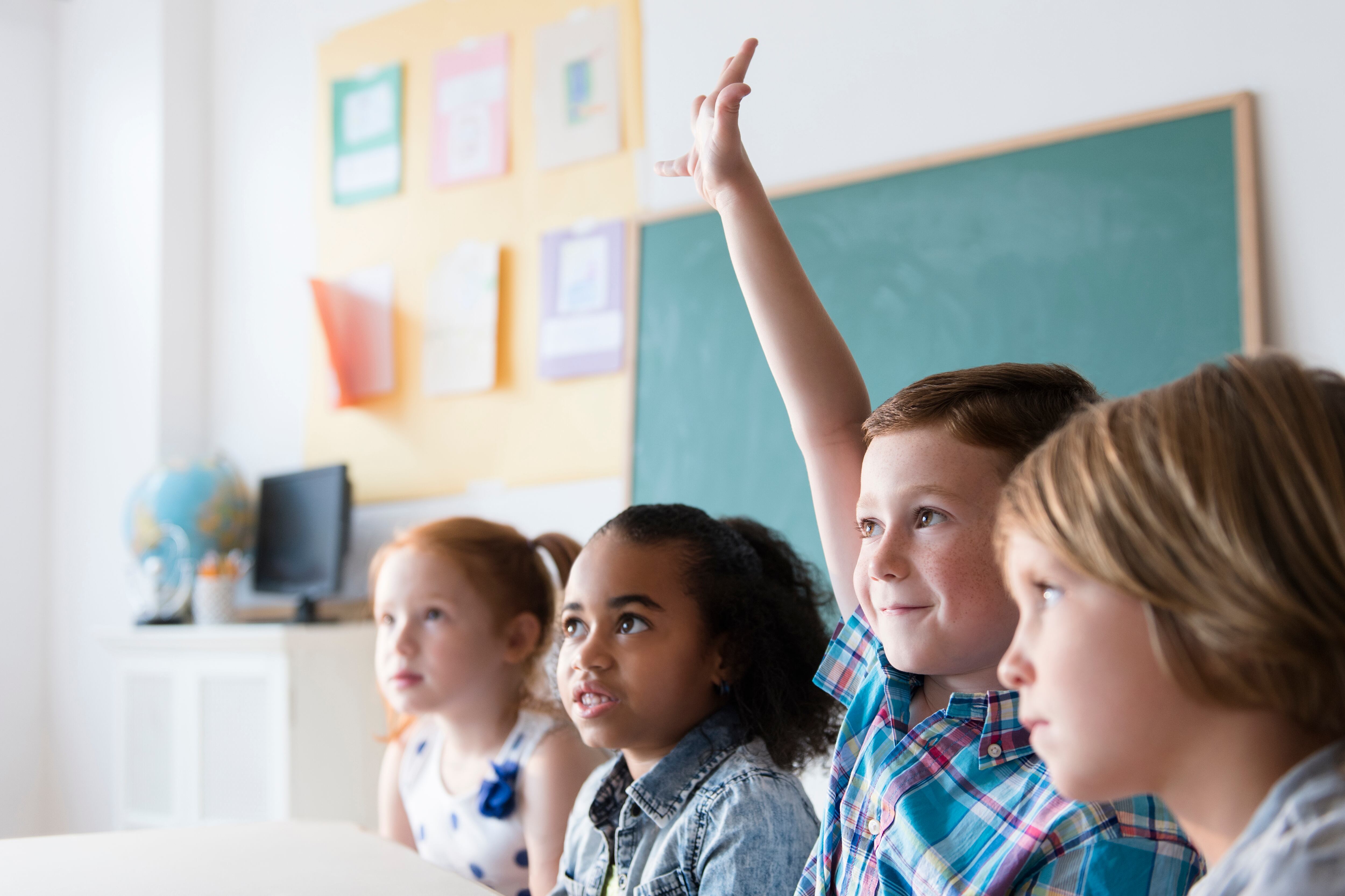 Un alumno levanta la mano en el aula