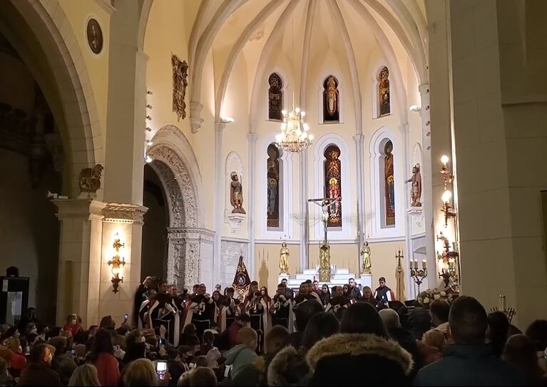 Imagen de la banda de cornetas y tambores de la cofradía de la Pasión de Peñafiel tocando a la imagen de la virgen en el interior de la iglesia de San Pablo