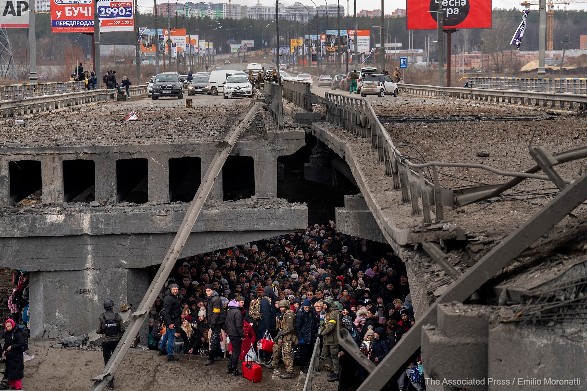 Los ucranianos se amontonan debajo de un puente destruido mientras intentan huir cruzando el río Irpin en las afueras de Kiev. Emilio Morenatti / AP