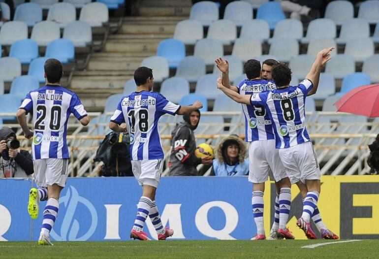 Real Sociedad's midfielder Xabi Prieto (R) is congrtulated by teammates forward Imanol Agirretxe (3R) and midfielder Esteban Granero (R) after scoring during the Spanish league football match Real Sociedad de Futbol vs Sevilla FC at the Anoeta stadium in San Sebastian on February 22, 2015. AFP PHOTO / ANDER GILLENEA