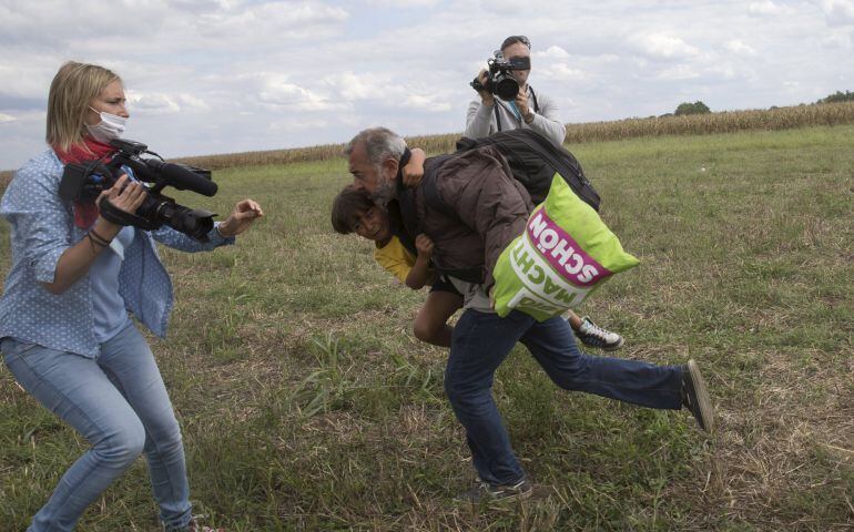 Un refugiado y su hijo son zancadilleados por una periodista en la frontera de Hungria