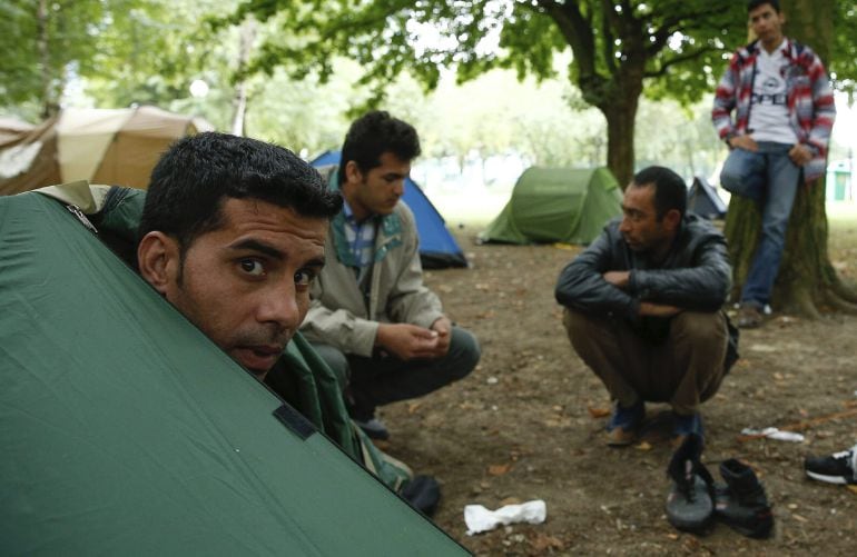 Varios refugiados descansan en un parque frente a la Oficina de Extranjería en Bruselas, Bélgica.