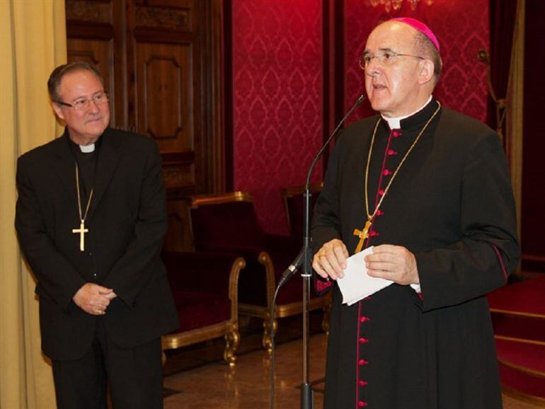 Esteban Escudero, a la izquierda, observa a Monseñor Osoro