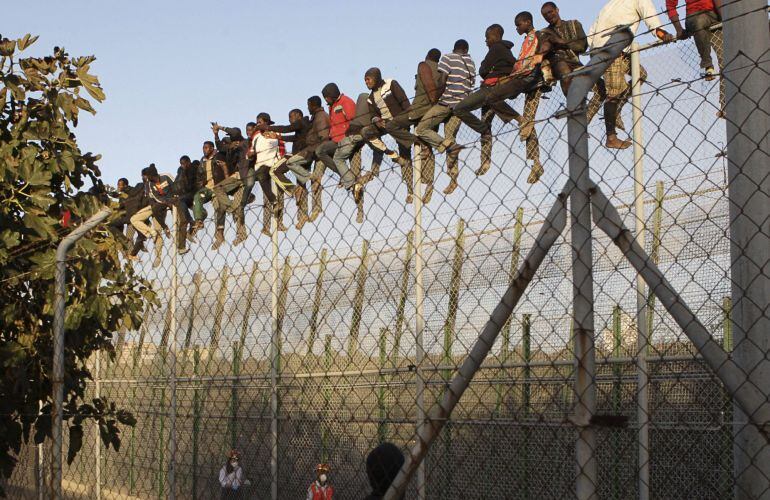 Inmigrantes encaramados a la valla de Melilla el 22 de octubre de 2014.