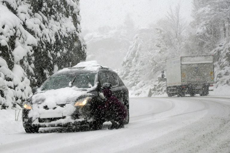 Un hombre pone las cadenas a su coche en la carretera A-136 entre el municipio de Biescas (Huesca) y la frontera con Francia en el puerto de el Portalet