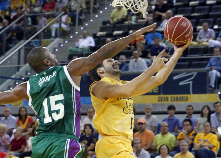 GRA187. LAS PALMAS DE GRAN CANARIA, 26/10/2014.- El base del Herbalife Gran Canaria, Tomás Bellas (d), intenta el lanzamiento ante el base del Unicaja Jayson Granger (i), durante el partido de la cuarta jornada de la Liga ACB que ambos equipos disputaron hoy en el Gran Canaria Arena, en Las Palmas de Gran Canaria. EFE/Elvira Urquijo A
