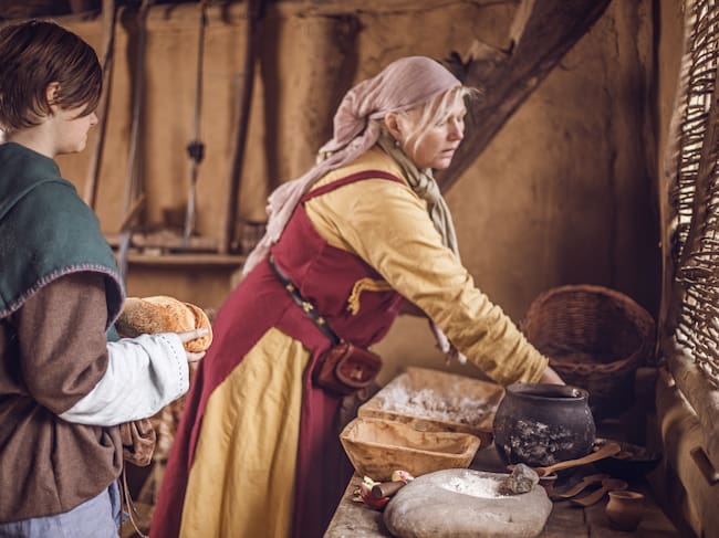 Una madre cocinando frente a su hijo.