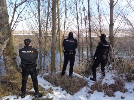 Agentes de la Policía Nacional en la otra orilla del río
