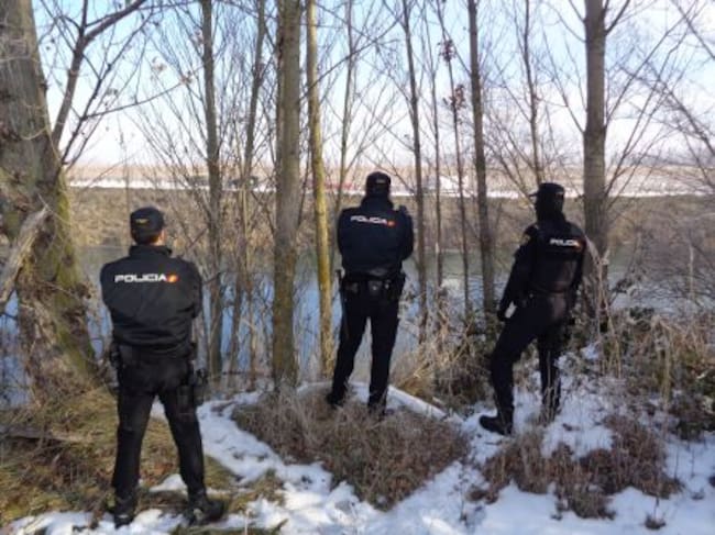 Agentes de la Policía Nacional en la otra orilla del río