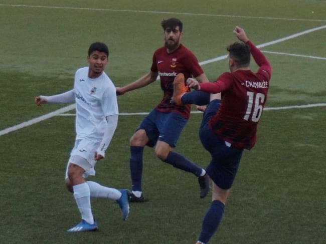 Juanjo Chavalés disputa un balón en presencia de Víctor Oliver