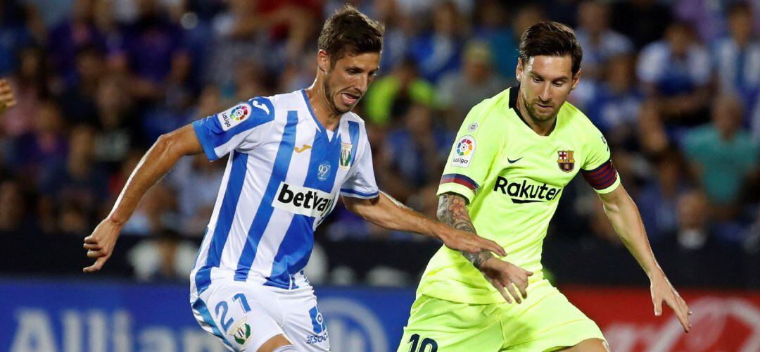 El delantero argentino del FC Barcelona, Lionel Messi (d) y el centrocampista del Leganés Rubén Pérez durante el partido de la sexta jornada de Liga.