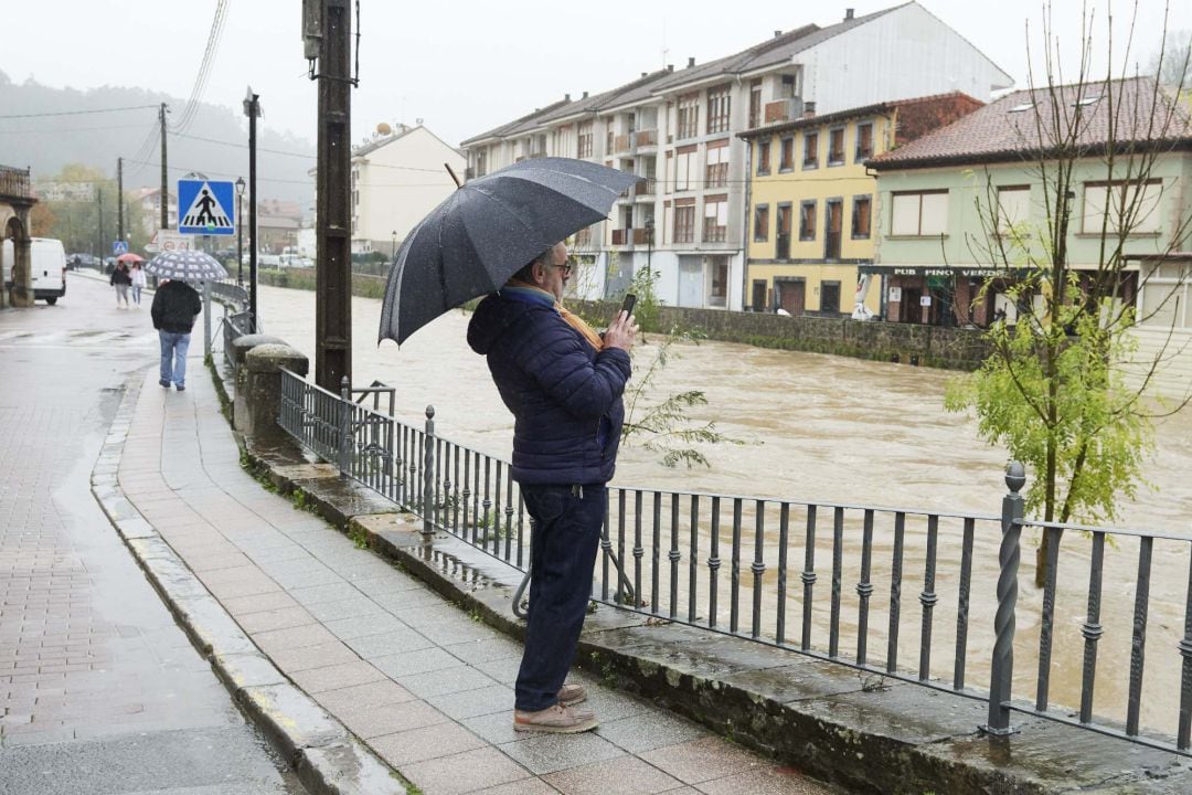 Un hombre observa las inundaciones debido a las fuertes lluvias en Cantabria.