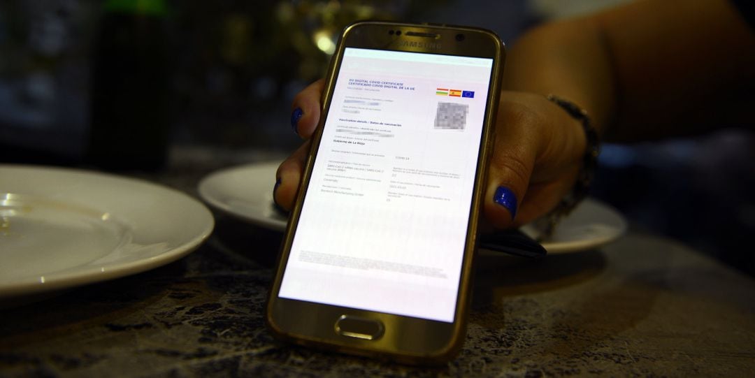 Archivo - Certificado digital de vacunación de una clienta de La Rioja en el casco histórico de Orense, a 24 de julio de 2021