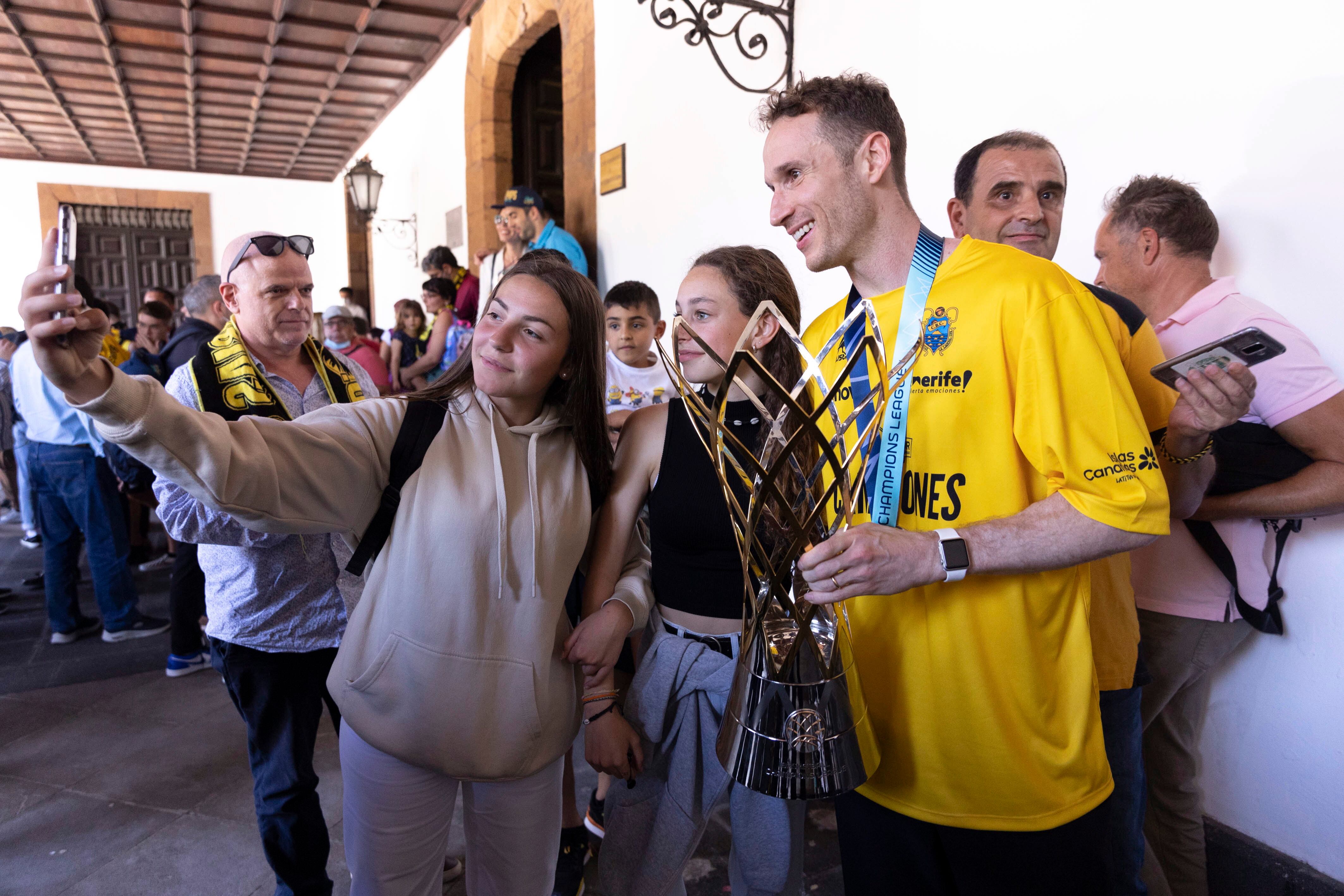 GRAFCAN4541. LA LAGUNA (TENERIFE), 09/05/2022.- El jugador del Lenovo Tenerife Marcelinho Huertas (d) se fotografía con varias aficionadas este lunes en el Ayuntamiento de La Laguna, donde el equipo fue recibido a su llegada a la isla tras proclamarse ayer campeón de la Basktetball Champions Leage .EFE/ Miguel Barreto