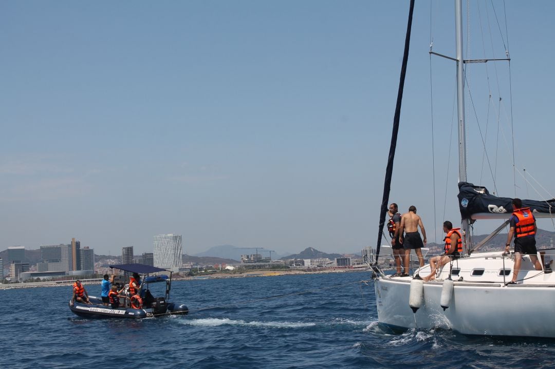 Una embarcació de la Unitat de Platges a prop d'un veler