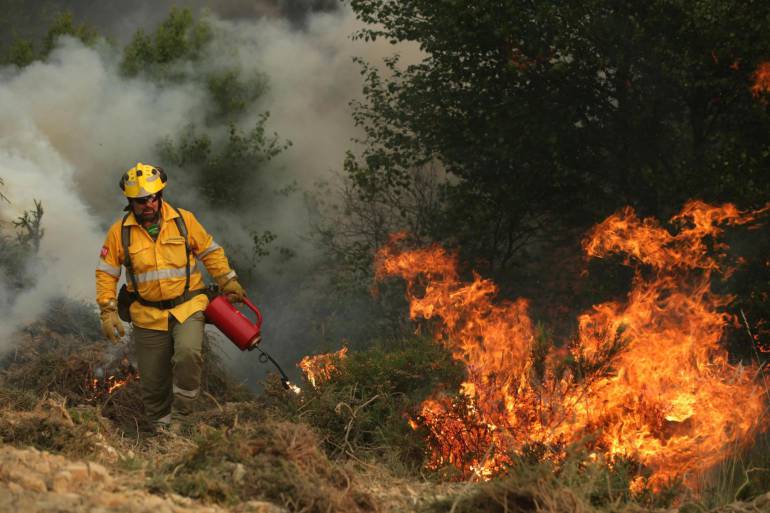 PT08. PAMPILHOSA DA SERRA (PORTUGAL) - Un bombero español enciende un fuego de manera controlada mientras combate un incendio en un bosque de Alto do Soeirinho