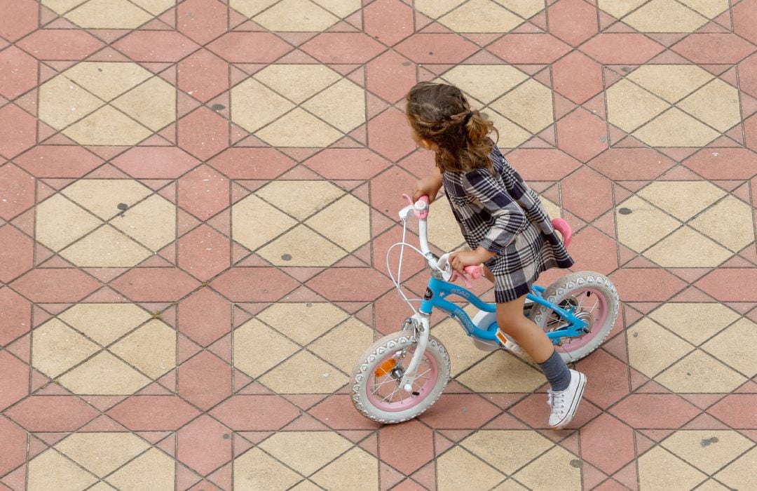 Una niña jugando con su bicicleta en la Plaza de España del Parque de Maria Luisa, en Sevilla.