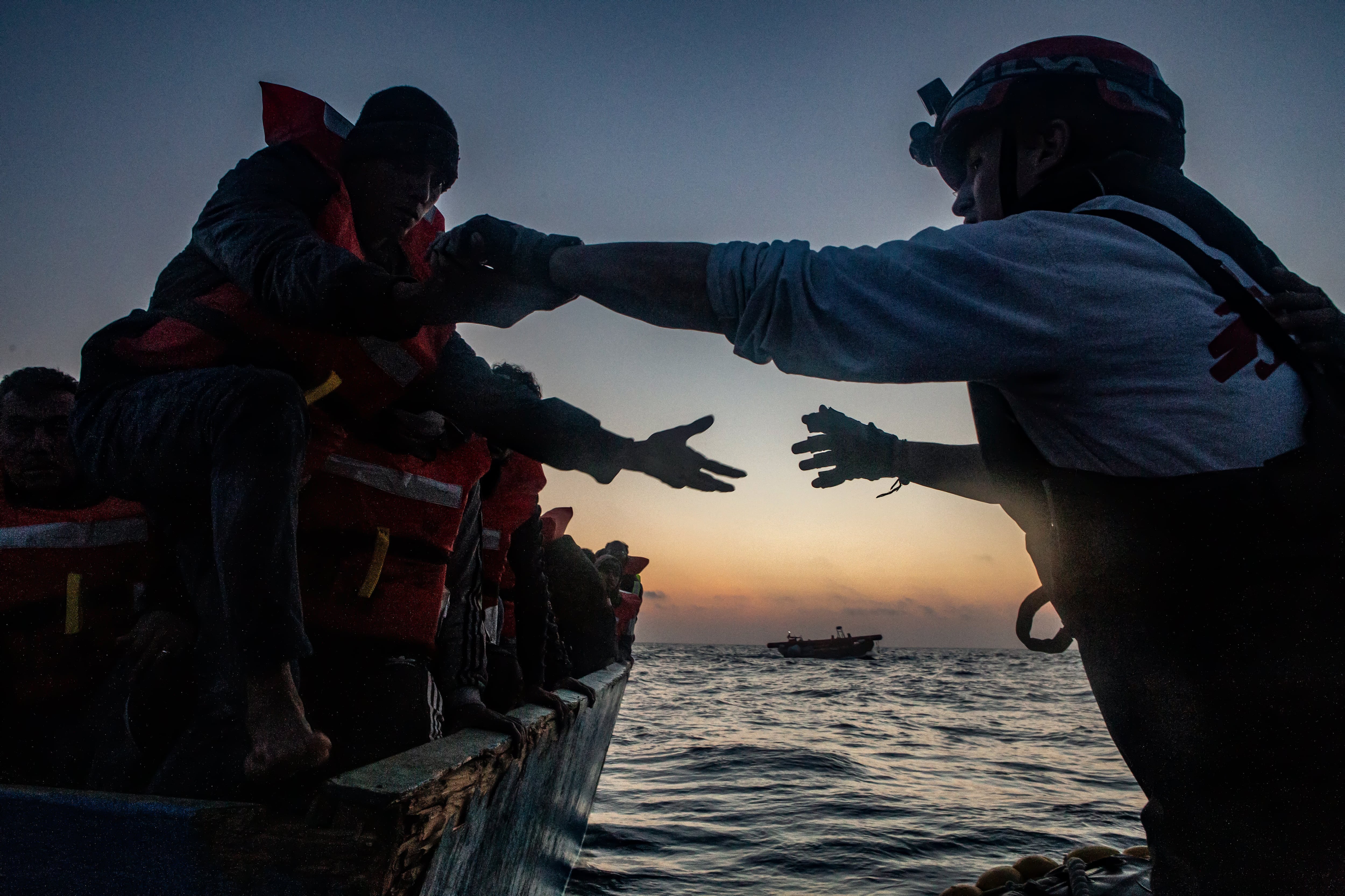 Varios inmigrantes son ayudados por la tripulación del Geo Barents, el barco de la ONG Médicos Sin Fronteras (MSF).