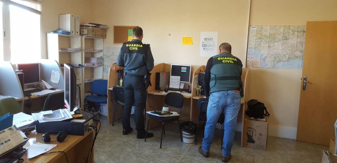 Agentes de la Guardia Civil recogen pruebas en la oficina.