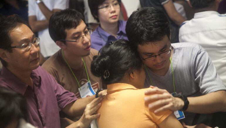 Familiares lloran al escuchar que los restos del avión desaparecido de AirAsia han sido localizados en alta mar