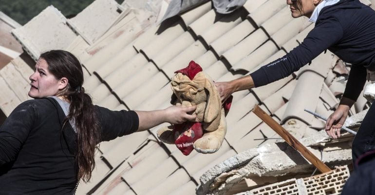 Dos mujeres sostienen un peluche en Amatrice, en el centro de Italia.