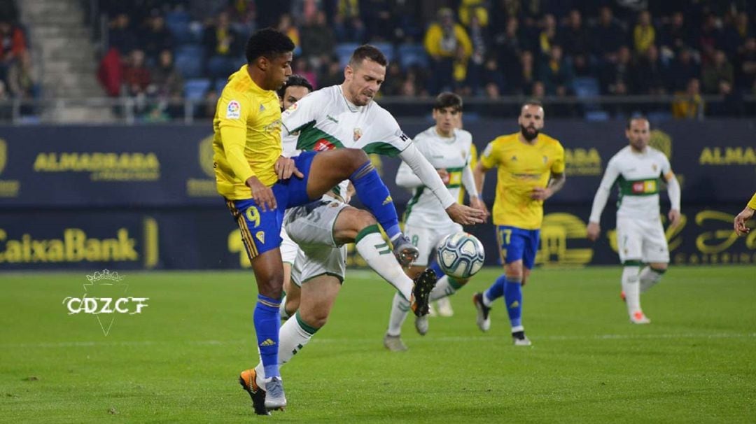 El jugador del Elche Manuel Sánchez pugna con el punta del Cádiz &quot;Choco&quot; Lozano