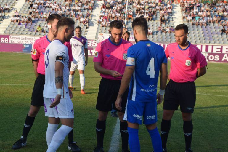 El árbitro realiza el sorteo de campo con los capitanes del Jaén y Linares